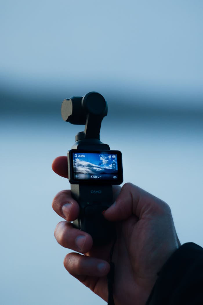 A person holds a compact camera, displaying a digital screen outdoors in Bodrum, Türkiye.